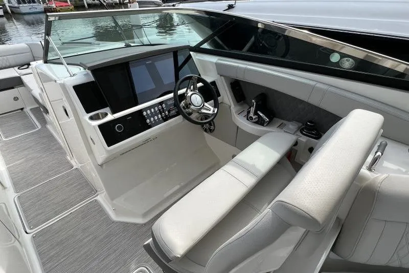 Slide: The Image of 2023 Sea Ray SLX 350 helm with modern controls and luxurious seating. - 76