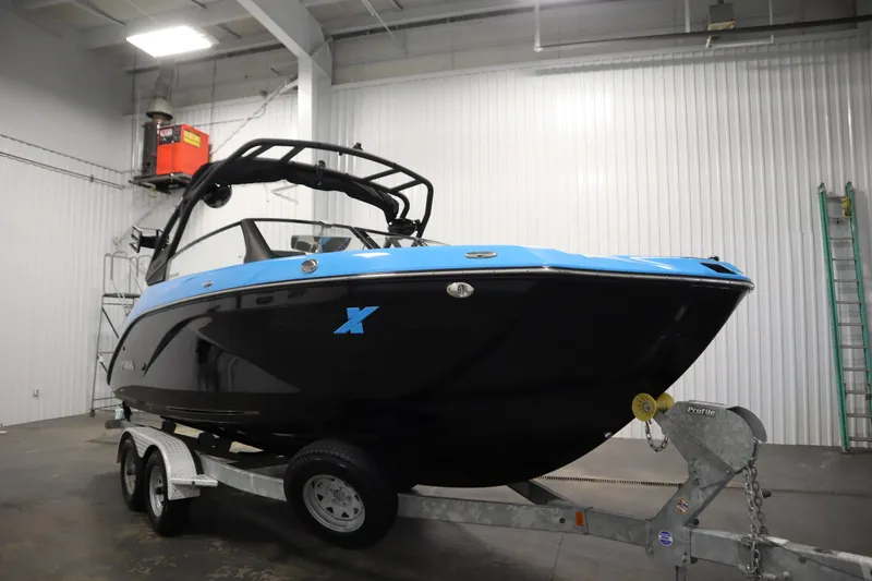 Slide: The Image of 2023 Yamaha Boats 222XD in a showroom, featuring a sleek black and blue design. - 3