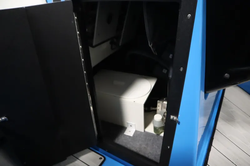 Slide: The Image of 2023 Yamaha Boats 222XD interior storage compartment with a portable toilet. - 30