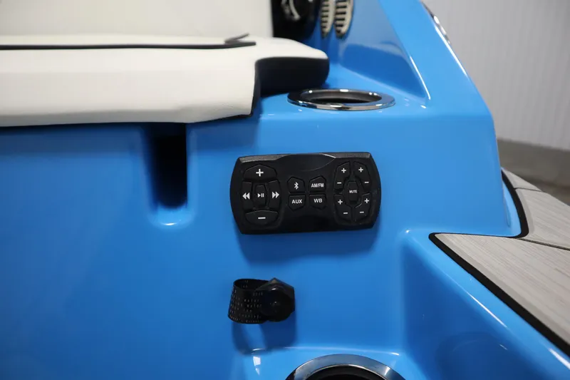 Slide: The Image of 2023 Yamaha Boats 222XD audio control panel on blue interior with cup holder. - 48