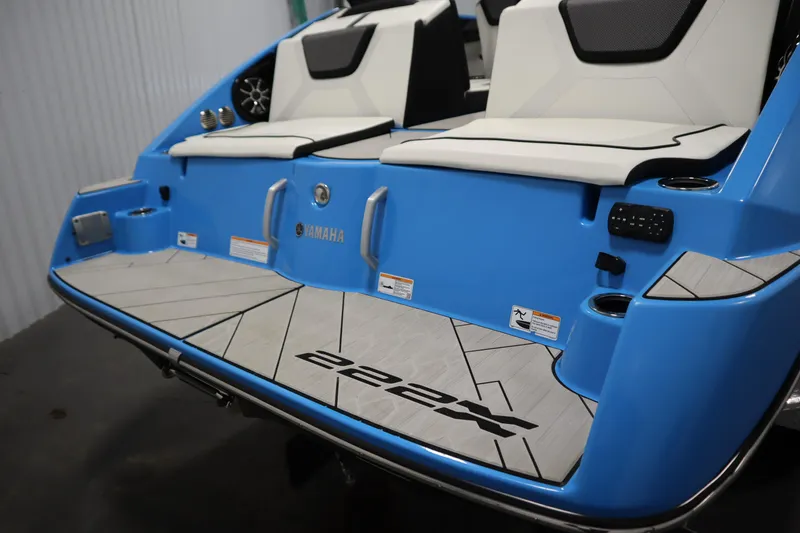 Slide: The Image of 2023 Yamaha Boats 222XD, blue exterior, rear seating and deck view. - 49