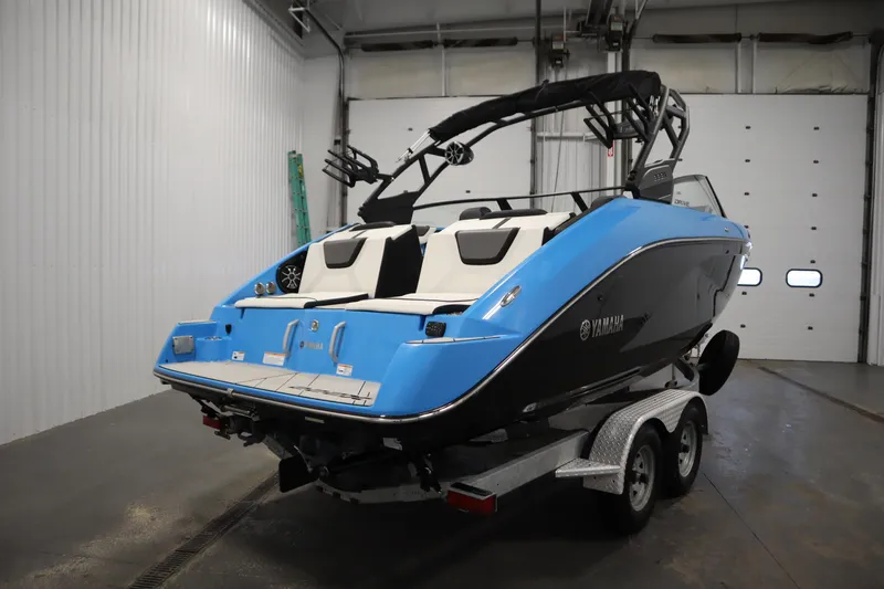 Slide: The Image of 2023 Yamaha Boats 222XD in a garage, blue and black design on a trailer. - 5