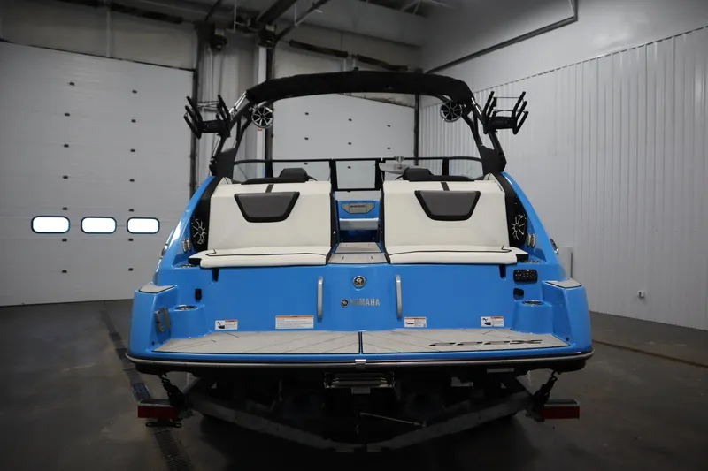 Slide: The Image of 2023 Yamaha Boats 222XD, blue exterior, rear view in indoor setting. - 6