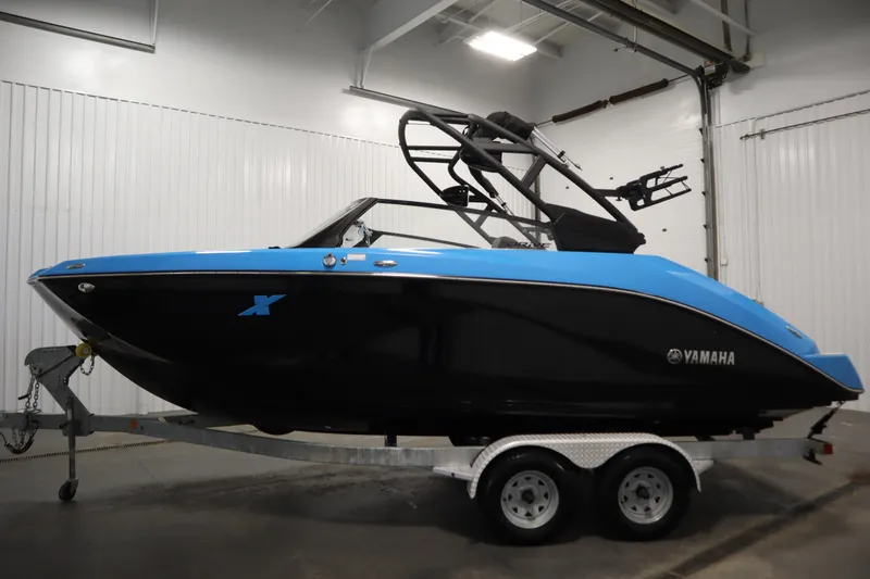 Slide: The Image of 2023 Yamaha Boats 222XD in blue and black on trailer, indoor setting. - 8