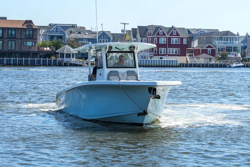 Slide: The Image of 2021 Sea Pro 320 DLX Offshore boat cruising near colorful waterfront homes. - 11
