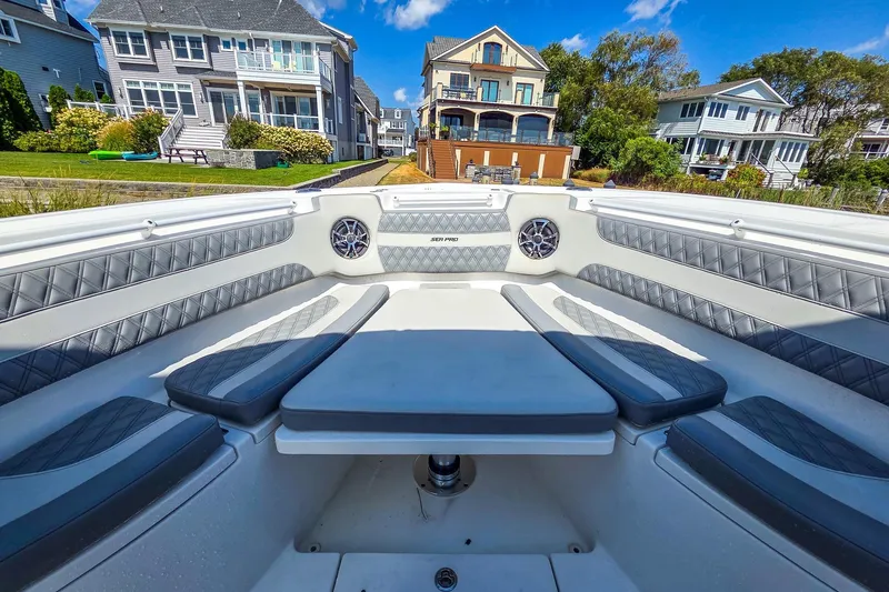 Slide: The Image of 2021 Sea Pro 320 DLX Offshore boat interior with luxurious seating and waterfront homes in background. - 12