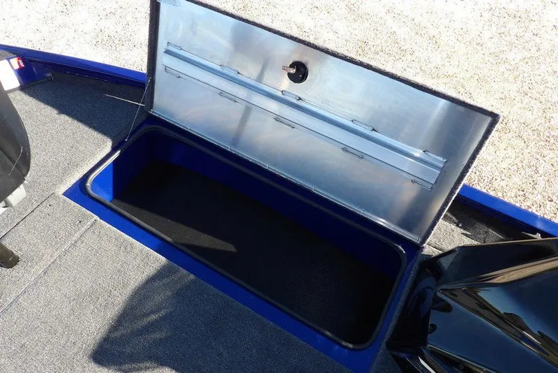 Slide: The Image of Open storage compartment in 2026 Crestliner XF 189 boat, featuring carpeted interior and metallic lid. - 26