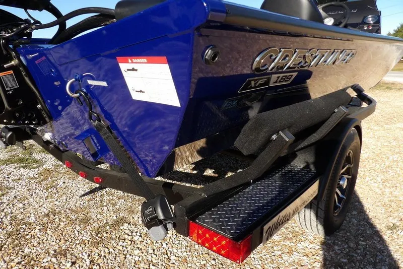 Slide: The Image of 2026 Crestliner XF 189 boat on trailer, featuring sleek blue design and secure strapping. - 44