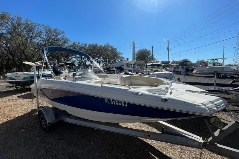 The Image of 2015 NauticStar 203SC Sport Deck boat on trailer, sunny day, outdoor display. - 1