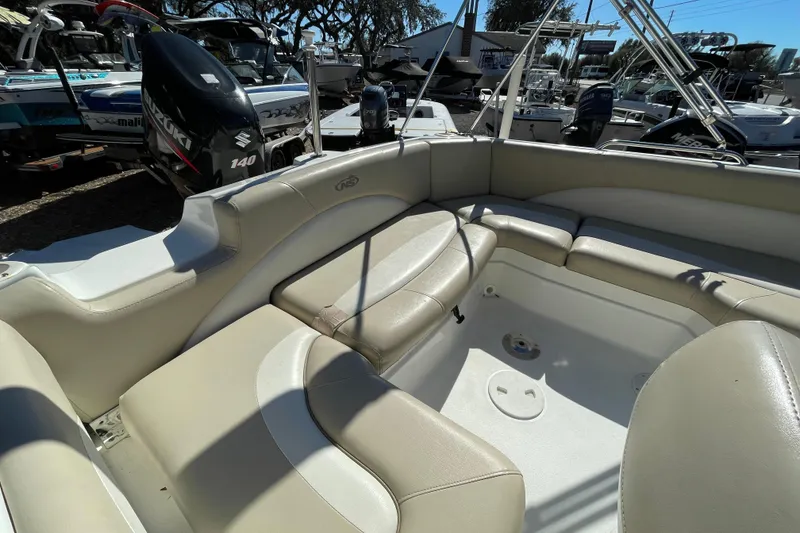 Slide: The Image of 2015 NauticStar 203SC Sport Deck boat interior with beige seating and Suzuki outboard motor. - 4