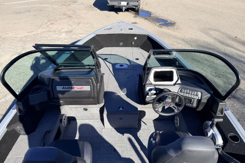 Slide: The Image of 2024 Alumacraft Competitor 175X Sport boat interior with steering console and seating. - 10