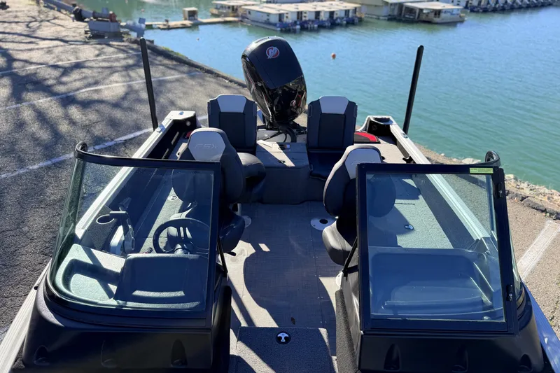Slide: The Image of 2024 Alumacraft Competitor 175X Sport boat docked by the water. - 12