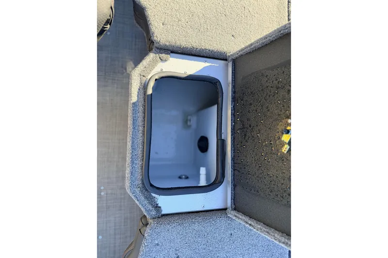 Slide: The Image of 2024 Alumacraft Competitor 175X Sport boat storage compartment, open and empty. - 13