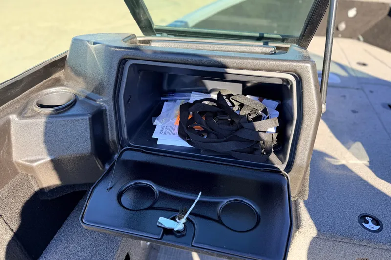 Slide: The Image of 2024 Alumacraft Competitor 175X Sport glove compartment with storage items and cup holders. - 21