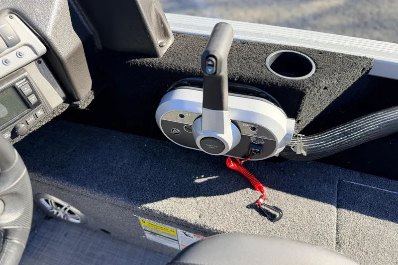 Slide: The Image of 2024 Alumacraft Competitor 175X Sport boat control panel with throttle and cup holder. - 25