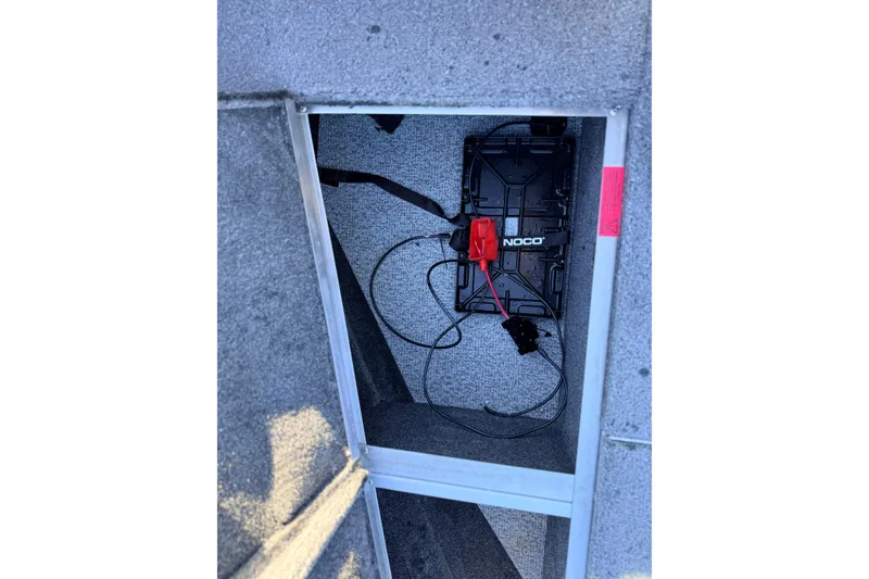 Slide: The Image of 2024 Alumacraft Competitor 175X Sport battery compartment with NOCO charger installed. - 30