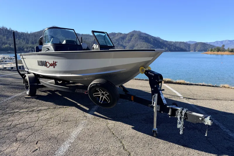 Slide: The Image of 2024 Alumacraft Competitor 175X Sport boat on trailer by scenic lake. - 7
