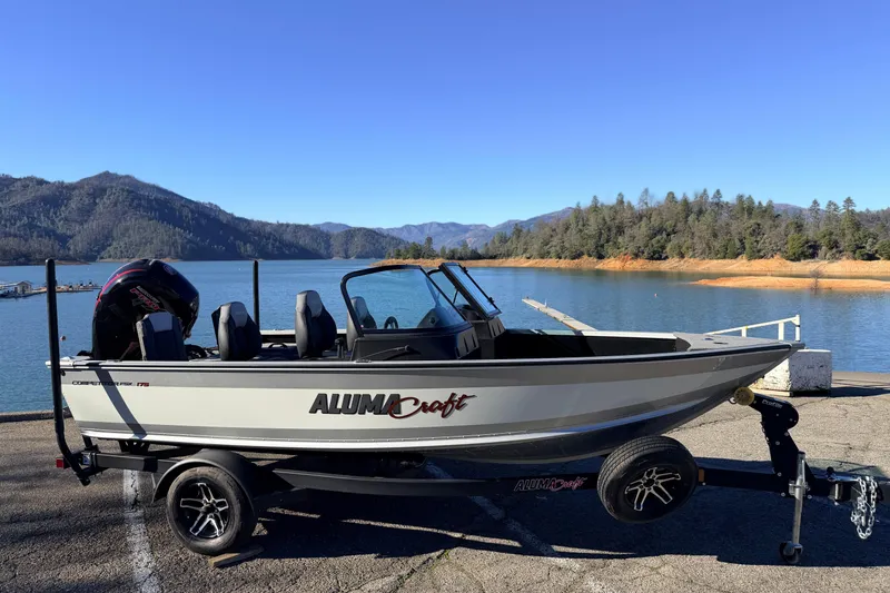 Slide: The Image of 2024 Alumacraft Competitor 175X Sport boat on trailer by scenic lake. - 8