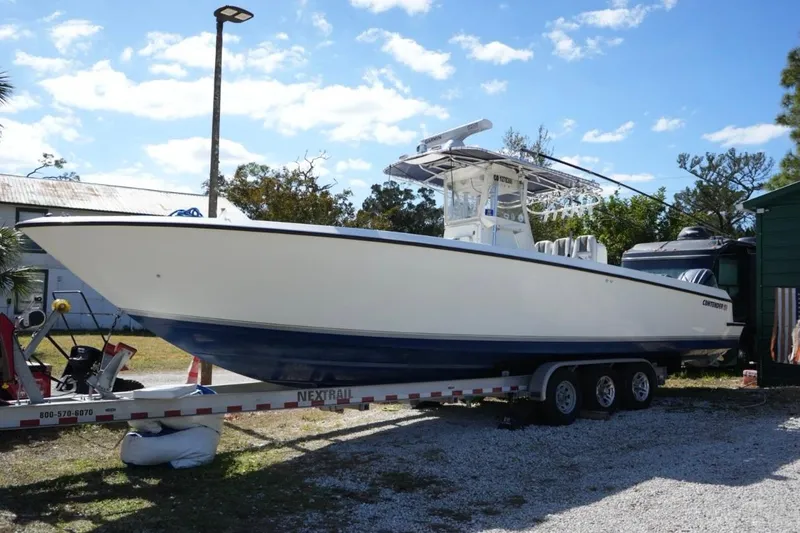 The Image of 2000 Contender 36 Open boat on trailer, parked outdoors under a clear sky. - 0