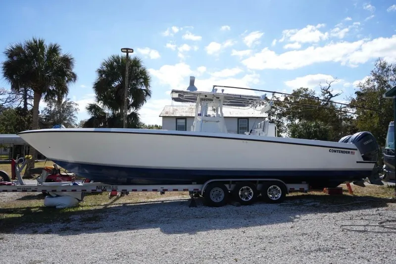 Slide: The Image of 2000 Contender 36 Open boat on trailer, parked outdoors under clear sky. - 1