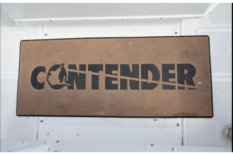 Slide: The Image of Contender 36 Open 2000 boat logo on wooden surface, featuring bold black lettering. - 24