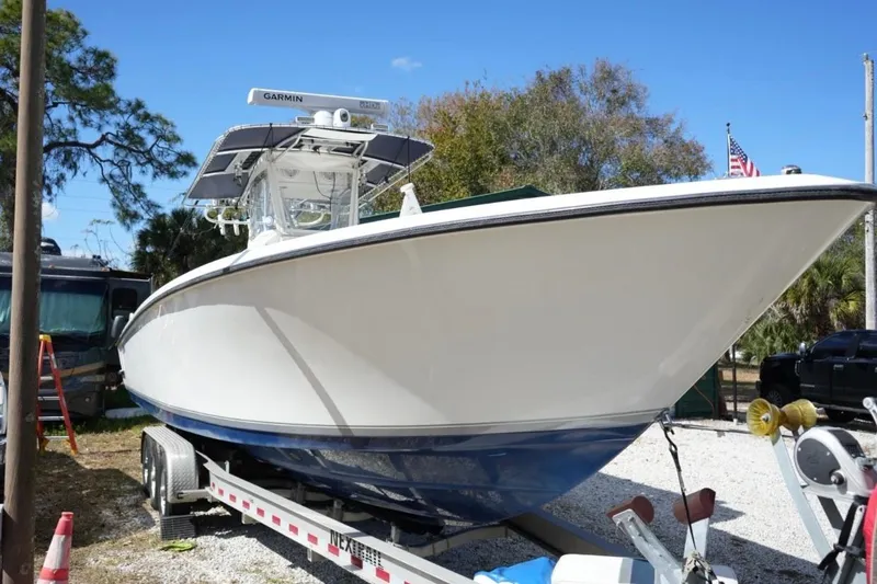 Slide: The Image of 2000 Contender 36 Open boat on trailer, parked outdoors under clear blue sky. - 25