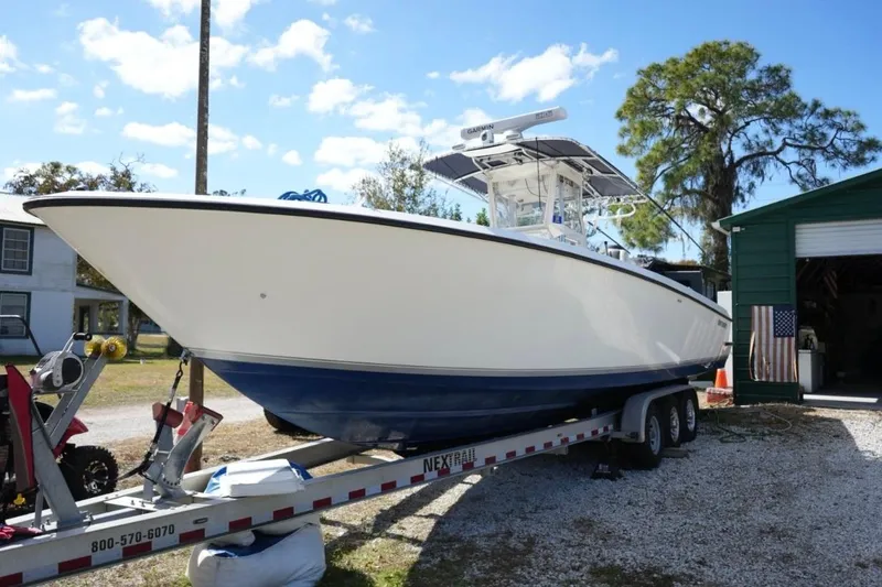 Slide: The Image of 2000 Contender 36 Open boat on trailer, parked outdoors near a green building. - 26