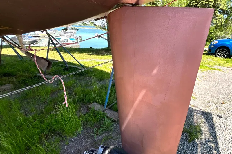 Slide: The Image of Keel of a 1985 Nonsuch 30 Ultra sailboat on a grassy boatyard. - 14