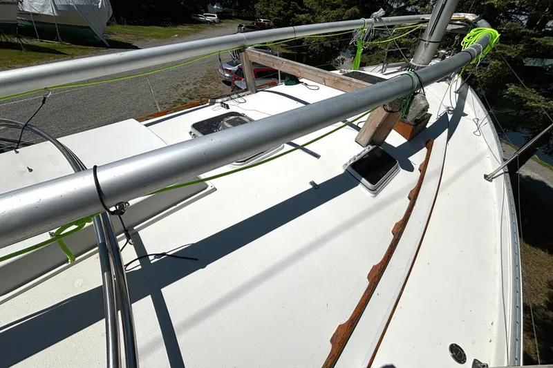 Slide: The Image of 1985 Nonsuch 30 Ultra sailboat deck with rigging and hatches, docked outdoors. - 24