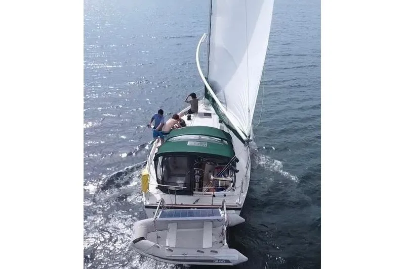 Slide: The Image of Sailing on a 1985 Nonsuch 30 Ultra yacht with green canopy on open water. - 3