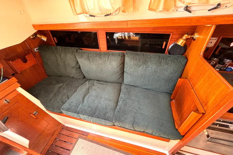 Slide: The Image of Cozy interior of 1985 Nonsuch 30 Ultra sailboat with green cushioned seating. - 31