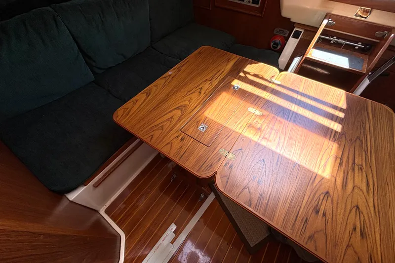 Slide: The Image of Interior of 1985 Nonsuch 30 Ultra sailboat with wooden table and cushioned seating. - 33