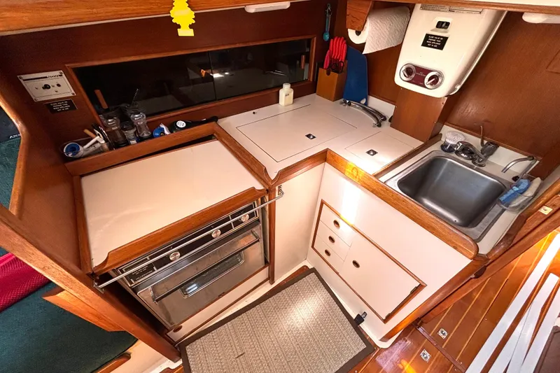 Slide: The Image of Compact galley kitchen in 1985 Nonsuch 30 Ultra sailboat with stove, sink, and storage. - 35
