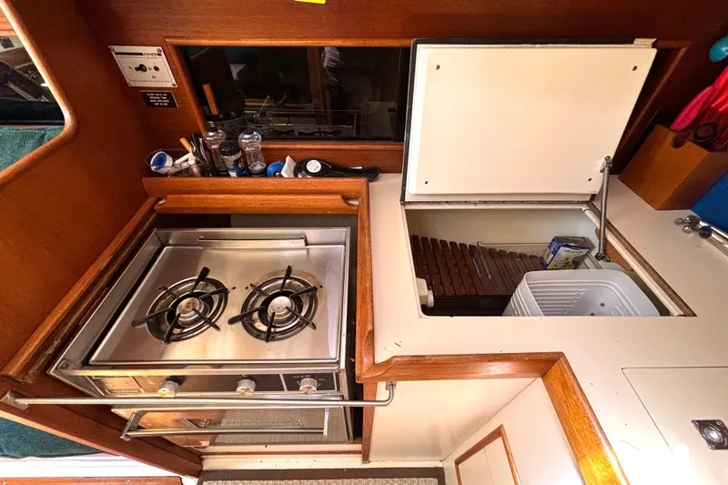 Slide: The Image of Compact galley kitchen in 1985 Nonsuch 30 Ulta sailboat with stove and storage. - 36