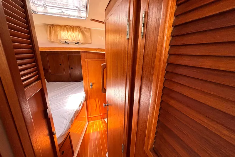 Slide: The Image of Interior of 1985 Nonsuch 30 Ultra sailboat with wooden cabinetry and cozy sleeping area. - 39
