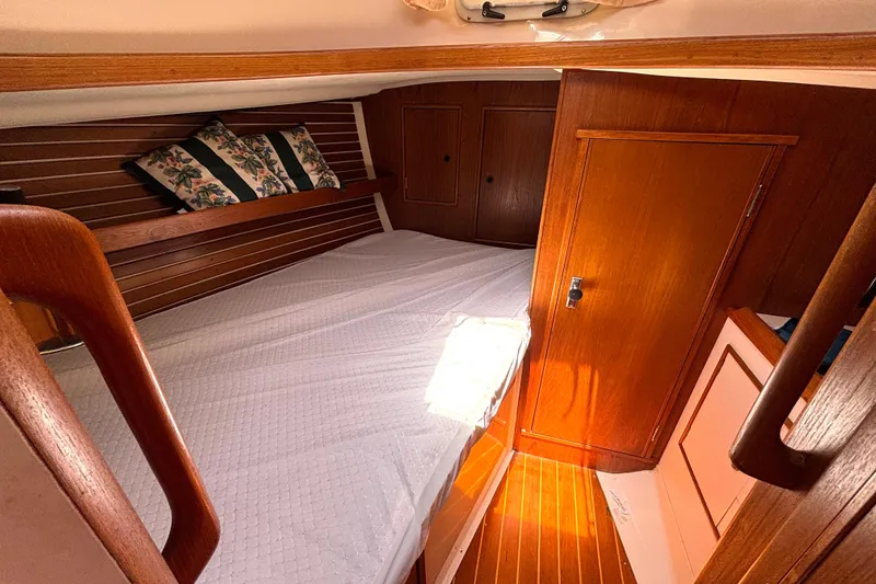 Slide: The Image of Cozy cabin interior of 1985 Nonsuch 30 Ultra sailboat with wooden finish and bedding. - 40