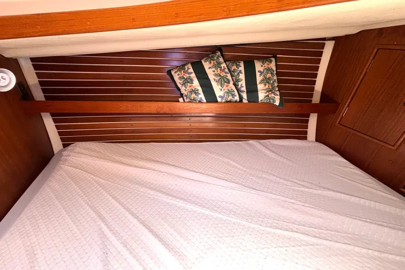 Slide: The Image of Cozy cabin interior of 1985 Nonsuch 30 Ultra sailboat with wooden paneling and floral pillows. - 41