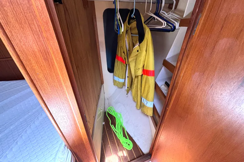 Slide: The Image of Small wooden closet in 1985 Nonsuch 30 Ulta sailboat with yellow jacket and green rope. - 43
