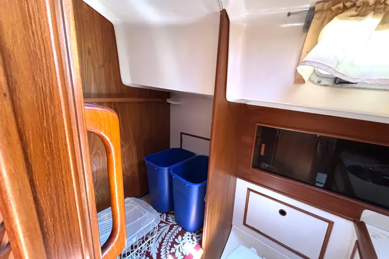 Slide: The Image of Interior of 1985 Nonsuch 30 Ultra sailboat with wooden cabinetry and storage bins. - 44