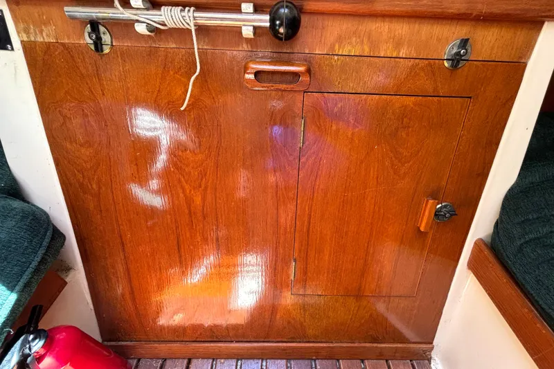 Slide: The Image of Wooden cabinet door on 1985 Nonsuch 30 Ulta sailboat interior, with fire extinguisher nearby. - 51