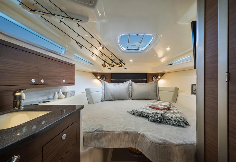 Slide: The Image of Manufacturer Provided Image: Luxurious cabin interior of 2026 Boston Whaler 325 Conquest with cozy bed and elegant wood finishes. - 12