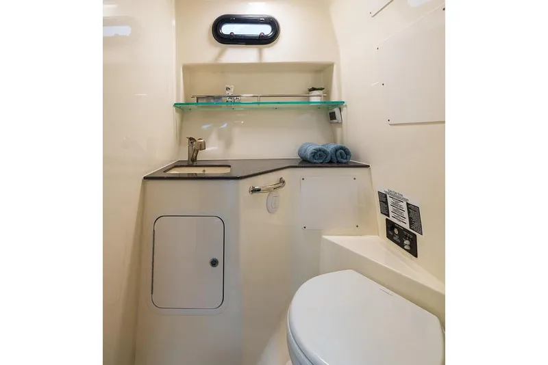 Slide: The Image of Manufacturer Provided Image: 2026 Boston Whaler 325 Conquest bathroom with sink, toilet, and storage shelves. - 15