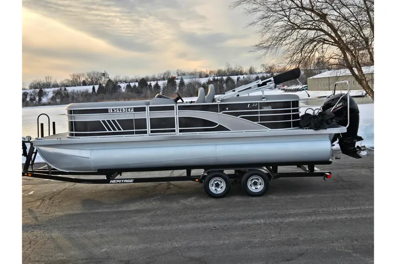 The Image of 2021 Bennington L 22 Quad Bench pontoon boat on trailer by snowy lake. - 0
