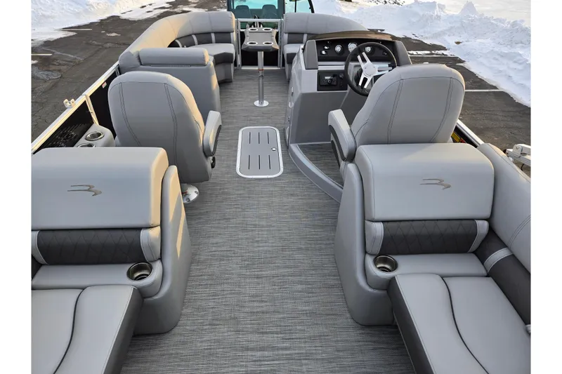 Slide: The Image of 2021 Bennington L 22 Quad Bench interior with luxurious gray seating and modern dashboard. - 18