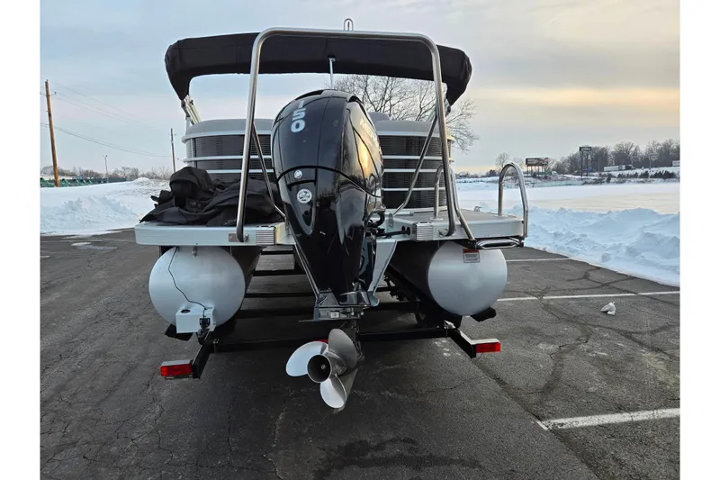 Slide: The Image of 2021 Bennington L 22 Quad Bench pontoon boat with outboard motor in snowy parking lot. - 2