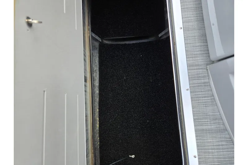 Slide: The Image of 2021 Bennington L 22 Quad Bench storage compartment with black carpet interior. - 21