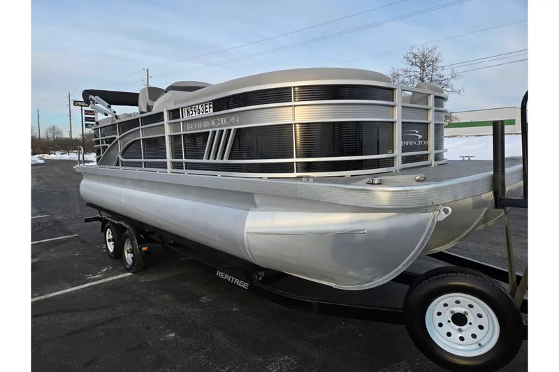 Slide: The Image of 2021 Bennington L 22 Quad Bench pontoon boat on trailer in parking lot. - 6