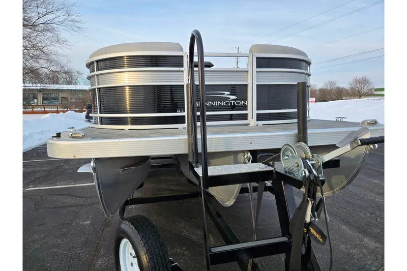 Slide: The Image of 2021 Bennington L 22 Quad Bench pontoon boat on trailer in snowy parking lot. - 7
