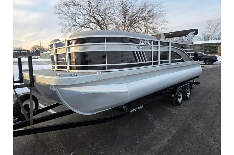 Slide: The Image of 2021 Bennington L 22 Quad Bench pontoon boat on trailer, parked outdoors. - 9