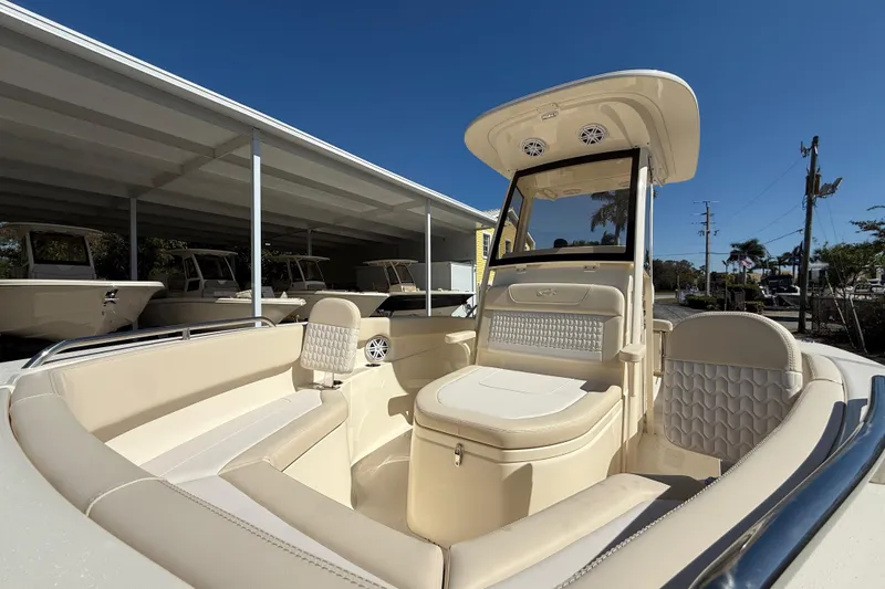 Slide: The Image of 2026 Scout 220 XSF boat interior with beige seating and modern design under clear blue sky. - 14